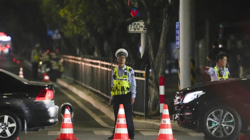 Um segurança fica de guarda perto de um centro esportivo onde um homem bateu com um carro em pessoas que se exercitavam em Zhuhai, China, em 11 de novembro de 2024. (Kyodo News via AP)
