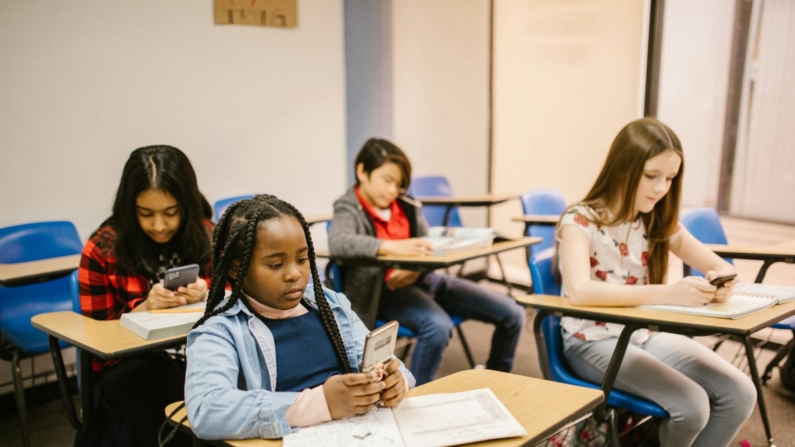 Crianças usando celular na escola (Foto: RDNE Stock project)