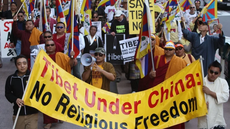 Membros e apoiadores da Associação Tibetana do Sul da Califórnia e dos Amigos do Tibete de Los Angeles marcham no 50º aniversário da primeira revolta tibetana contra o governo chinês e a fuga do 14º Dalai Lama para o exílio, em Los Angeles, Califórnia, em 10 de março de 2009 (David McNew/Getty Images)