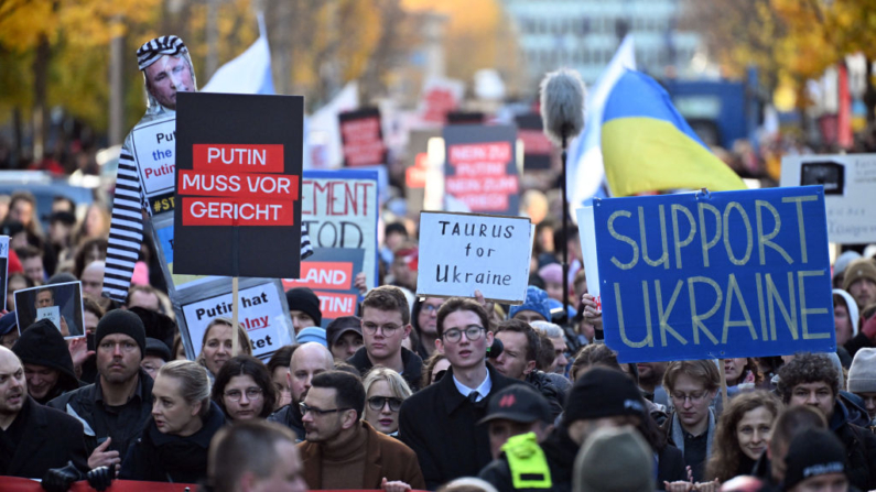 Apoiadores da oposição exilada da Rússia marcham com cartazes em apoio à Ucrânia e contra o líder russo Putin durante uma manifestação em Berlim, Alemanha, em 17 de novembro de 2024. A oposição russa, forçada ao exílio e enfraquecida por conflitos internos, organiza sua primeira grande manifestação contra a invasão da Ucrânia por Moscou em Berlim no domingo, testando sua credibilidade política no terceiro ano da guerra. (Foto de RALF HIRSCHBERGER / AFP) (Foto de RALF HIRSCHBERGER/AFP via Getty Images)
