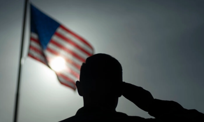 Um soldado saudando a bandeira americana. Sargento da equipe (Lexie West/Força Aérea dos EUA via AP)
