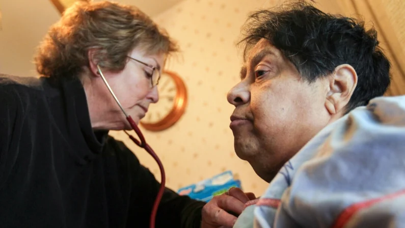 enfermeira registrada verifica a respiração de um paciente que sofre de diabetes grave, durante uma visita de assistência médica domiciliar em Thornton, Colorado, em 24 de fevereiro de 2010. (John Moore/Getty Images)
