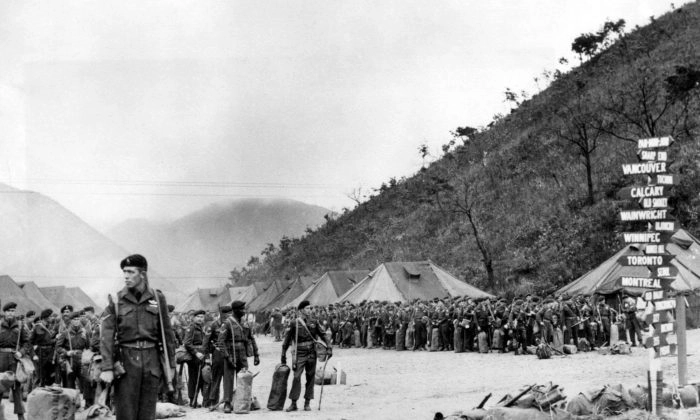 Membros do Primeiro Batalhão da Infantaria Leve Canadense da Princesa Patricia se alinham com seus equipamentos enquanto esperam para voltar para casa após o fim da Guerra da Coreia. A placa de sinalização à direita aponta para as principais cidades canadenses e posições militares na Coreia. (AP)
