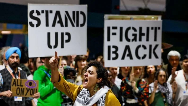 Ativistas gritam slogans durante uma ação de protesto na conferência da ONU sobre mudanças climáticas COP29, em Baku, Azerbaijão, em 23 de novembro de 2024. (Reuters/Maxim Shemetov)