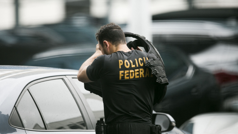 A federal police officer takes off his bulletproof vest at the Federal Police headquarters in Rio de Janeiro, Brazil, on March 24, 2024. Brazilian police carried out an operation on March 24, 2024, to arrest the alleged "masterminds" of the 2018 murder of Rio de Janeiro councilwoman Marielle Franco, a crime that caused outrage in Brazil and abroad. (Photo by Daniel Ramalho / AFP) (Photo by DANIEL RAMALHO/AFP via Getty Images)