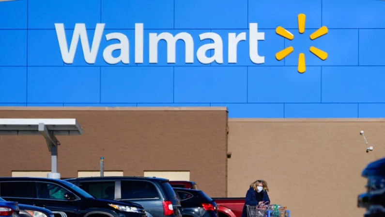 Uma mulher leva um carrinho com suas compras para fora de uma loja Walmart em Derry, N.H., em 18 de novembro de 2020 (Charles Krupa/AP Photo)