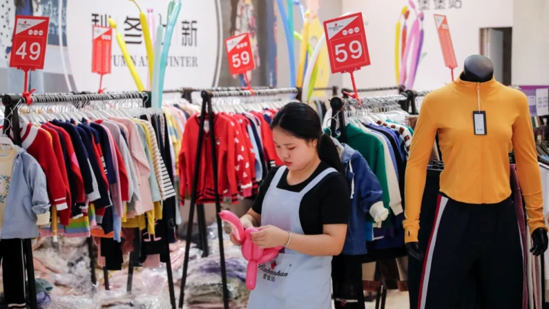 Um funcionário usa balões para atrair clientes em um varejista de moda que está fazendo uma promoção de vendas em um shopping center em Shenzhen, província de Guangdong, na China, em 1º de novembro de 2019 (Andy Wong/AP)