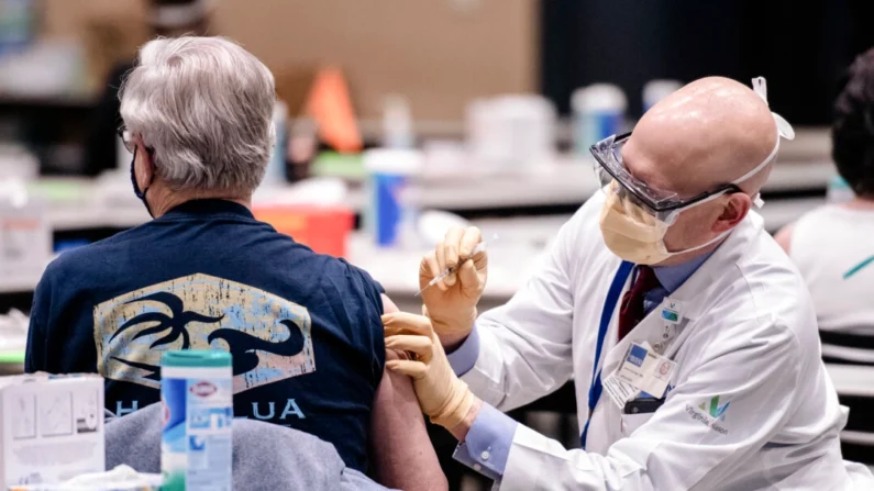 Um homem recebe uma dose da vacina Pfizer contra a COVID-19 no centro de Seattle em 24 de janeiro de 2021. (Grant Hindsley/AFP via Getty Images)