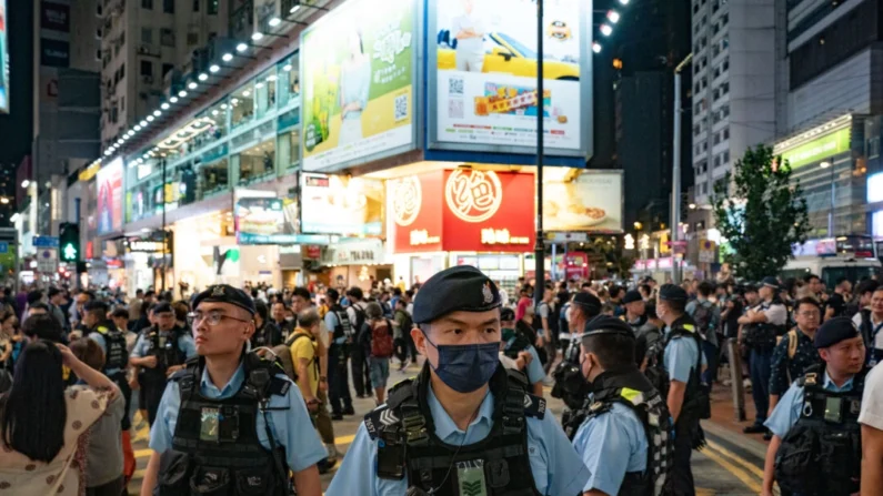 Policiais patrulham o distrito de Causeway Bay, próximo ao Victoria Park, onde as pessoas tradicionalmente se reúnem anualmente para lamentar as vítimas do massacre da Praça Tiananmen na China em 1989, em Hong Kong, em 4 de junho de 2024. Anthony Kwan/Getty Images
