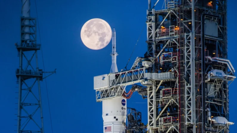 Uma lua cheia é vista por trás do sistema de lançamento espacial Artemis I e a espaçonave Orion, no topo do lançador móvel no Complexo 39b de lançamento no Kennedy Space Center da NASA na Flórida em 14 de junho de 2022. (Cory Huston/NASA via AP)
