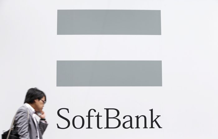 Foto de arquivo mostrando uma pessoa falando ao telefone ao lado do logotipo da SoftBank Corp. em Tóquio, Japão (EPA/KIYOSHI OTA/FILE)