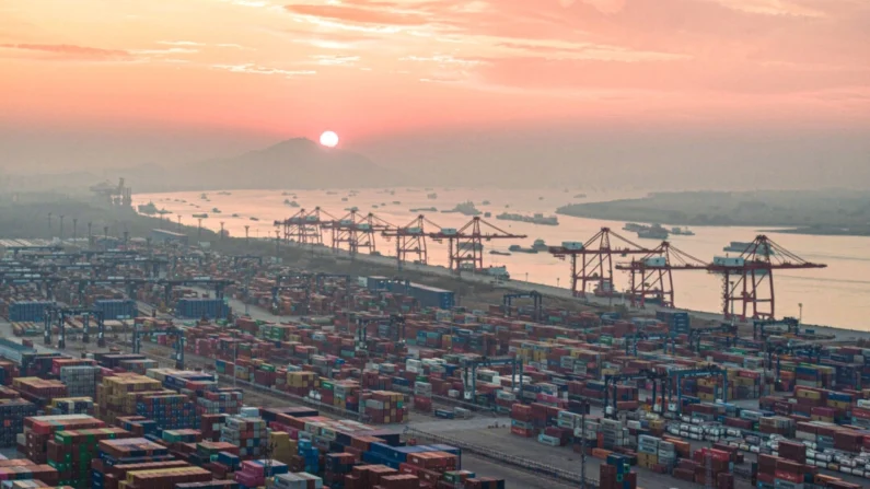 Contêineres empilhados durante o pôr do sol no porto de Nanjing, na província de Jiangsu, leste da China, em 4 de janeiro de 2024. (STR/AFP via Getty Images)
