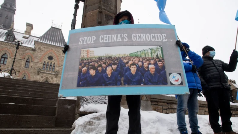 Manifestantes contra o abuso da China contra muçulmanos uigures se reúnem do lado de fora dos prédios do Parlamento em Ottawa em 22 de fevereiro de 2021, enquanto os parlamentares votam em uma moção pedindo ao Canadá que reconheça as ações da China contra a minoria étnica como genocídio. (The Canadian Press/Adrian Wyld)
