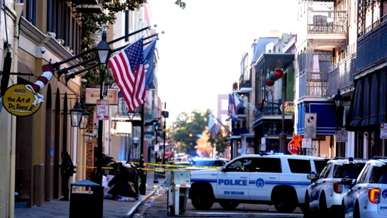 Veículos de serviço de emergência formam uma barreira de segurança para manter outros veículos fora do French Quarter depois que um veículo atingiu uma multidão no Canal e na Bourbon Street de Nova Orleans em 1º de janeiro de 2025 (Foto de Gerald Herbert/AP)