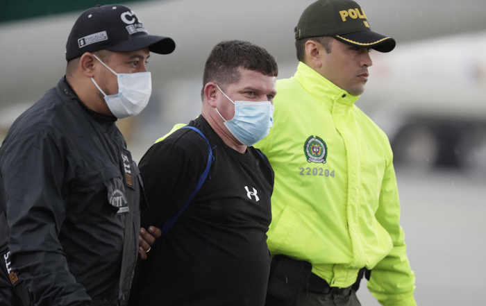 Foto de arquivo de 8 de junho de 2022 de Francisco Luis Correa Galeano (c) sendo transferido por um agente da Polícia e do Corpo Técnico de Investigação (CTI) no Comando de Transporte Aéreo Militar (CATAM) para o bunker da Procuradoria Geral da República, em Bogotá (Colômbia) (EFE/ Carlos Ortega)