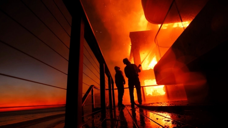 Bombeiros trabalham em um deque enquanto o incêndio em Palisades queima uma propriedade à beira-mar em Malibu, Califórnia, em 8 de janeiro de 2025. (Etienne Laurent/AP Photo)