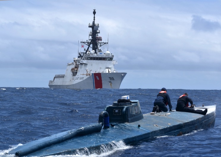 Crew members of the U.S. Coast Guard Cutter Munro inspect a self-propelled semi-submersible suspected drug smuggling vessel (SPSS) in international waters of the Eastern Pacific Ocean, on June 19, 2019. (U.S. Coast Guard Photo)