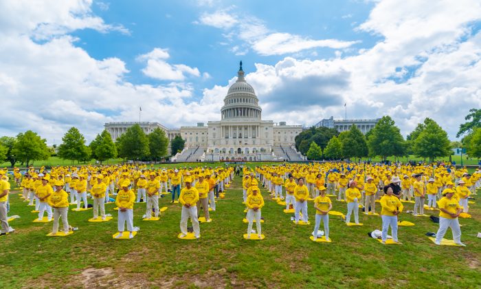 Praticantes do Falun Dafa realizam seus exercícios em uma cerimônia comemorativa do 20º aniversário da perseguição ao Falun Dafa na China, no jardim oeste do Capitólio, em 18 de julho de 2019. (Mark Zhou / The Epoch Times)