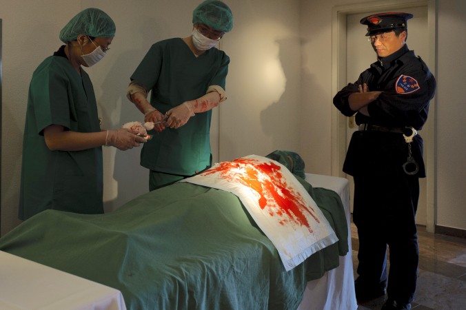 Praticantes do Falun Dafa reconstroem a extração de órgãos durante uma reunião da Sociedade Internacional pelos Direitos Humanos em Cottbus, Alemanha, em 14 de abril de 2012 (Robert Michael / AFP / Getty Images)