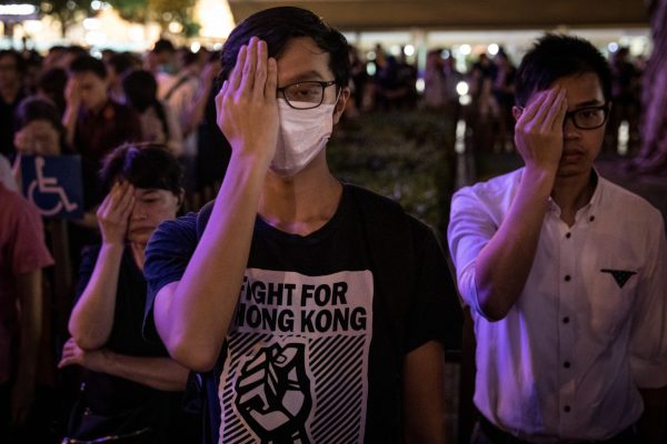 Manifestantes cobrem os olhos esquerdos e permanecem em silêncio durante a 74a Assembléia do Aniversário da Libertação de Hong Kong, em 30 de agosto de 2019 (Chris McGrath / Getty Images)