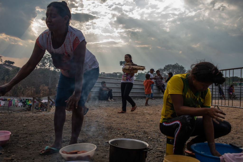 Membros do grupo indígena venezuelano Warao preparam comida no abrigo da ONU Janokoida em 6 de abril de 2019 em Pacaraima, Brasil. Mais de 900 pombos indígenas foram deslocados para o Brasil como resultado do medo, da ameaça que eles têm (Victor Moriyama / Getty Images)