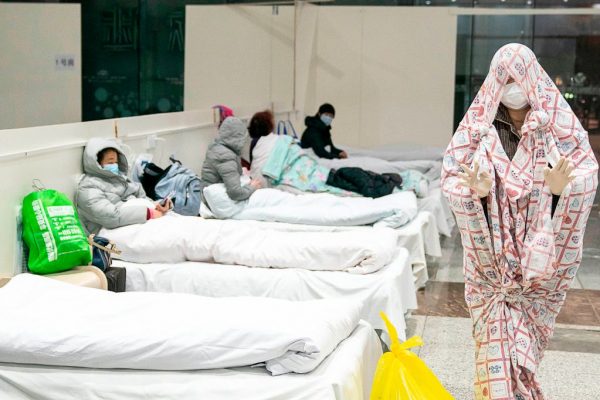 Um paciente é coberto com um cobertor em um centro de exposições transformado em hospital quando começa a aceitar pacientes com sintomas do novo coronavírus em Wuhan, na província central de Hubei, na China, em 5 de fevereiro de 2020 (STR / AFP via Getty Images)