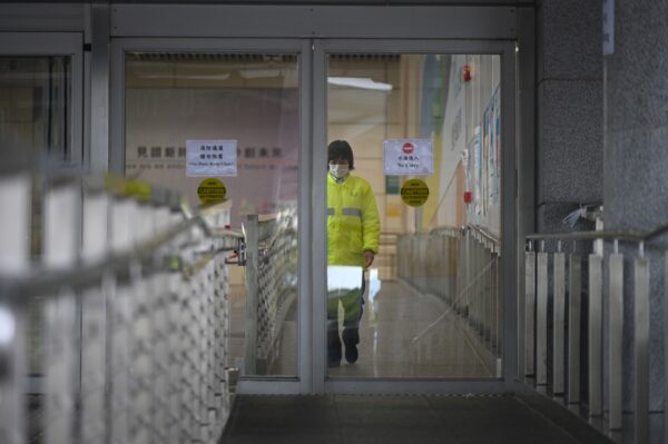 Um trabalhador que usa uma máscara como medida preventiva após um surto de coronavírus iniciado na cidade chinesa de Wuhan caminha na área portuária de Hong Kong no porto da Baía de Shenzhen em 8 de fevereiro de 2020 (Philip Fong / AFP via Getty Images)