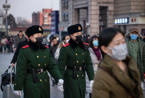 Policiais chineses usam máscaras protetoras enquanto estão em patrulha na estação de Pequim antes do Festival da Primavera anual em 22 de janeiro de 2020 em Pequim, China (Kevin Frayer / Getty Images)