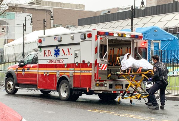 Profissionais de saúde transportam um paciente de uma ambulância em frente ao Elmhurst Hospital Center em Elmhurst, Nova York, em 29 de março de 2020 (Chung I Ho / The Epoch Times)