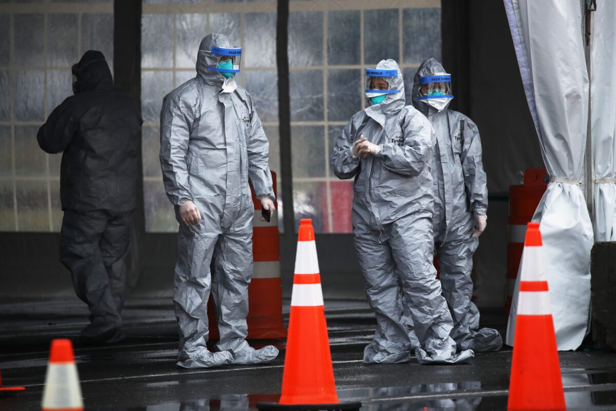 Trabalhadores com equipamentos de proteção operam um centro de testes móvel COVID-19 em New Rochelle, Nova Iorque, em 13 de março de 2020 (Spencer Platt / Getty Images)