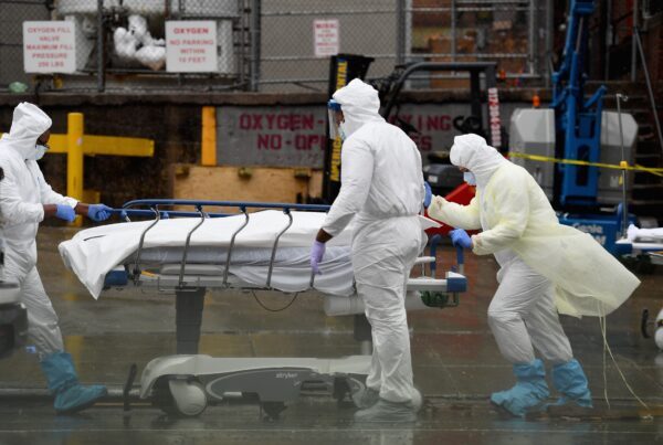 A equipe médica transporta um paciente falecido para um caminhão refrigerado que serviu de necrotério improvisado no Brooklyn Hospital Center, em Nova Iorque, em 9 de abril de 2020 (Angela Weiss / AFP via Getty Images)