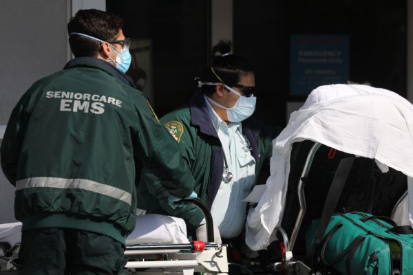 Trabalhadores médicos transportam pacientes para fora de uma área especial de admissão ao coronavírus no Maimonides Medical Center em 21 de abril de 2020 no bairro Borough Park, no distrito de Brooklyn, em Nova Iorque (Spencer Platt / Getty Images)