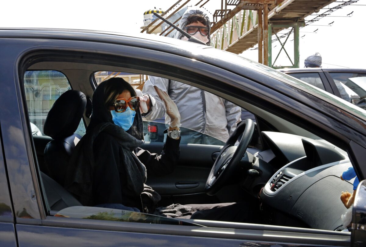 Membros do Crescente Vermelho Iraniano testam pessoas para sintomas de COVID-19 nos arredores de Teerã, Irã, em 26 de março de 2020 (STR / AFP / Getty Images)