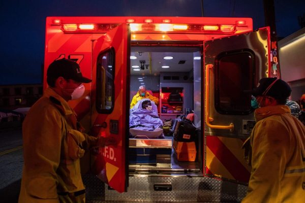 Paramédicos cuidam de uma pessoa com possíveis sintomas de COVID-19 em Los Angeles, Califórnia, em 12 de abril de 2020 (Apu Gomes / AFP / Getty Images)