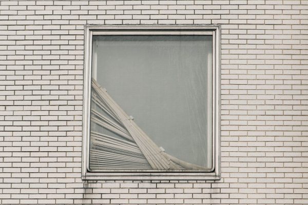 Cortinas quebradas são vistas em uma janela no Brookdale Hospital Medical Center, no Brooklyn, Nova York, em 13 de abril de 2020 (Scott Heins / Getty Images)