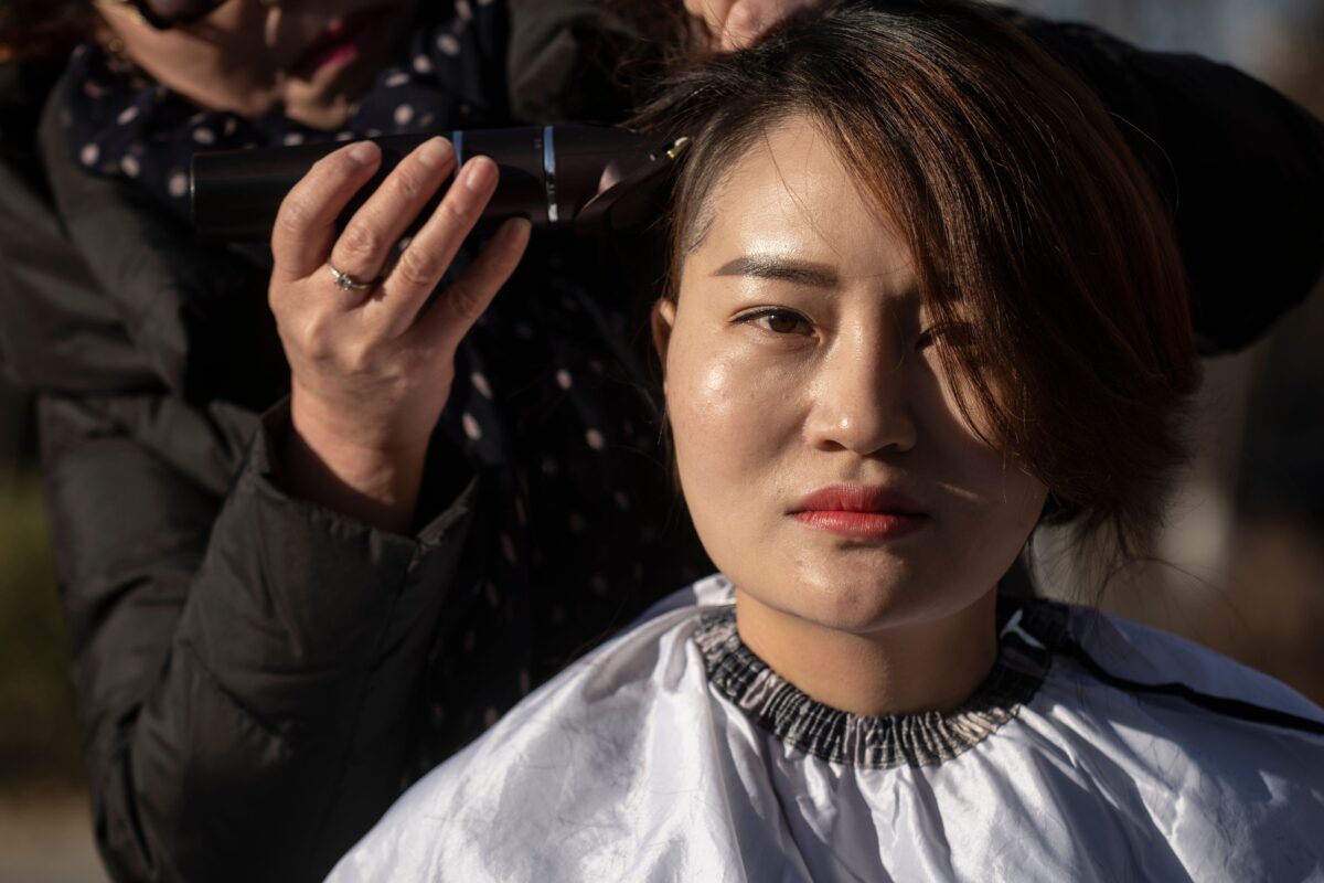 Li Wenzu raspou a cabeça para protestar contra a prisão de seu marido, o advogado chinês de direitos humanos Wang Quanzhang, detido durante a repressão do 709, em Pequim, em 17 de dezembro de 2018 (Fred Dufour / AFP via Getty Images)