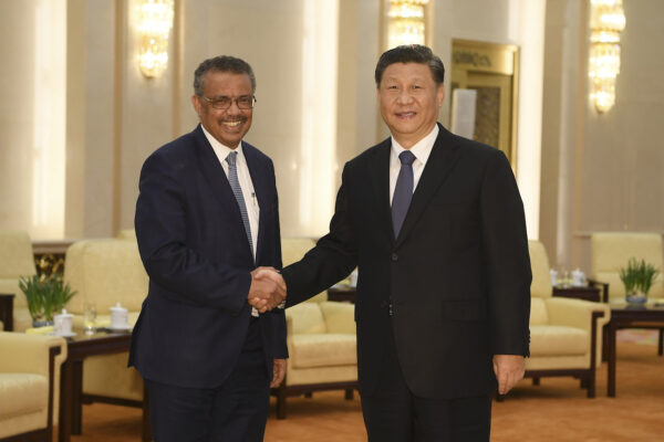 O diretor-geral da Organização Mundial da Saúde Tedros Adhanom (E) aperta a mão do líder do regime chinês Xi Jinping antes de uma reunião no Grande Salão do Povo em Pequim em 28 de janeiro de 2020 (Naohiko Hatta / AFP via Getty Images)