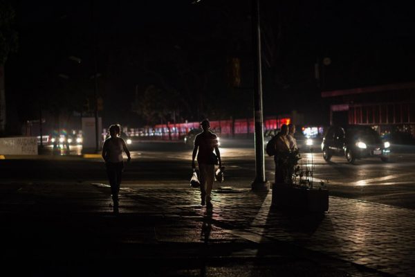 As pessoas andam por uma rua escura durante um novo apagão em Caracas, Venezuela, em 30 de março de 2019. Foto por (CRISTIAN HERNANDEZ / AFP / Getty Images)