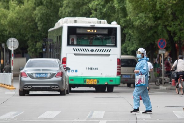 Uma mulher atravessa uma rua em Wuhan, China, em 11 de maio de 2020 (STR / AFP via Getty Images)