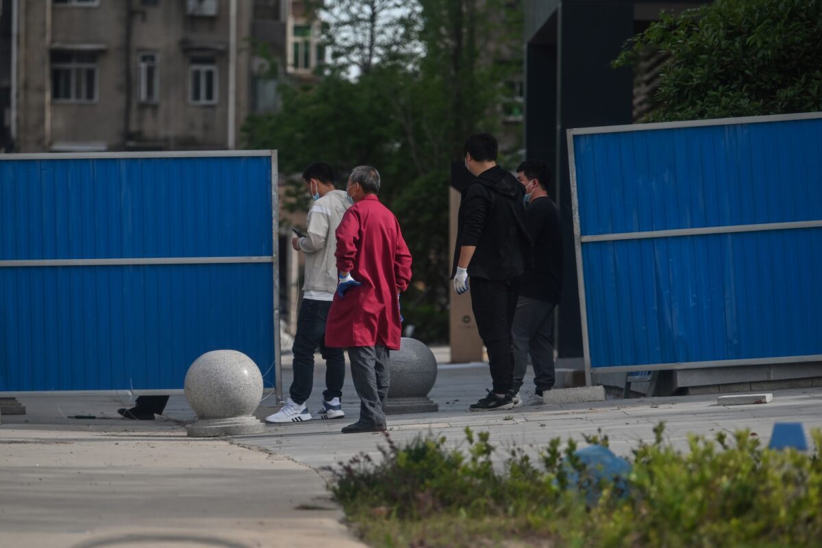 Residentes fazem fila no complexo residencial Sanmin para receber um teste de ácido nucléico depois que seis residentes foram diagnosticados com o vírus do PCC em Wuhan, China, em 12 de maio (HECTOR RETAMAL / AFP via Getty Images)