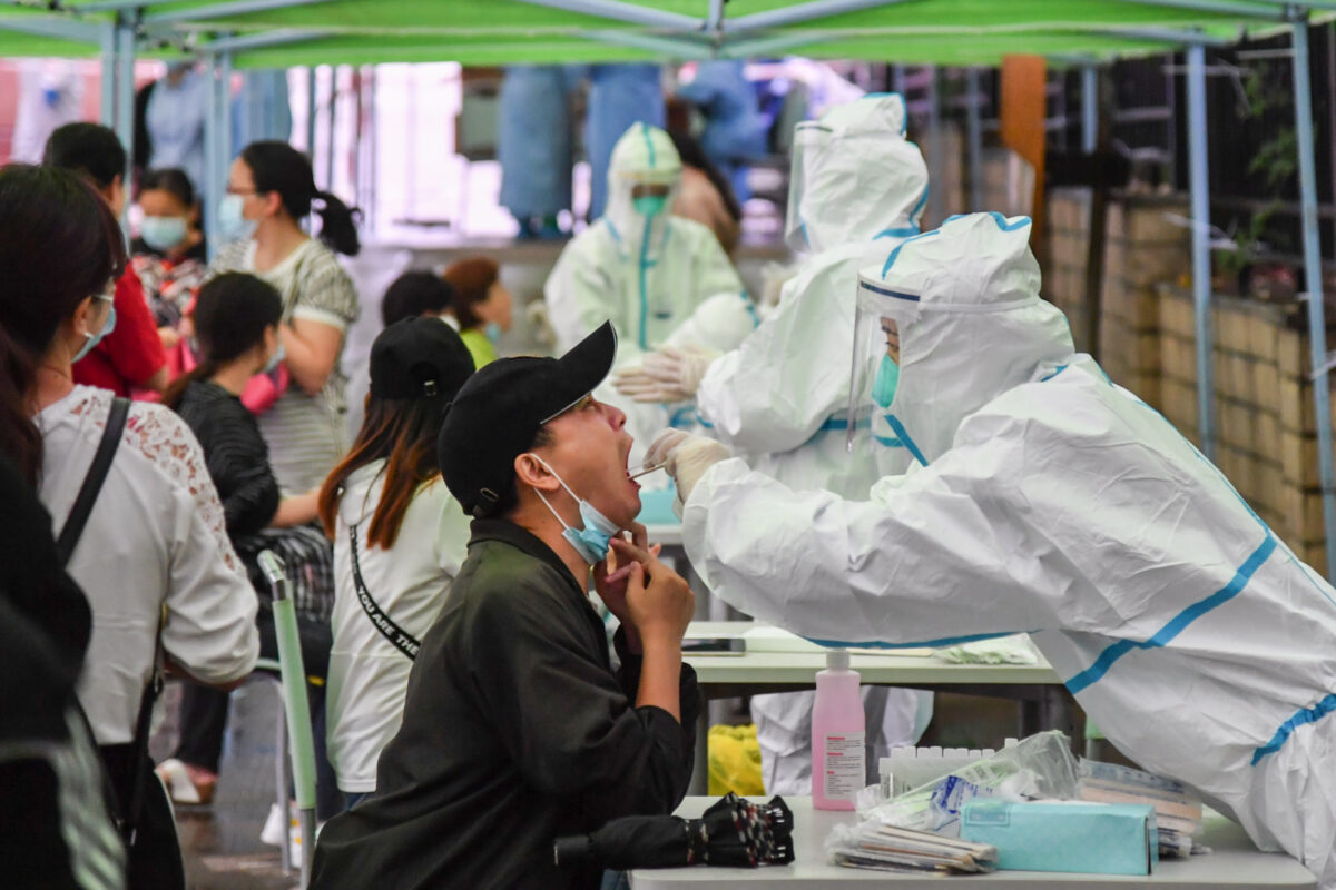 Um trabalhador médico colhe uma amostra de swab de um residente para testar o coronavírus em Wuhan, China, em 14 de maio de 2020 (STR / AFP via Getty Images)