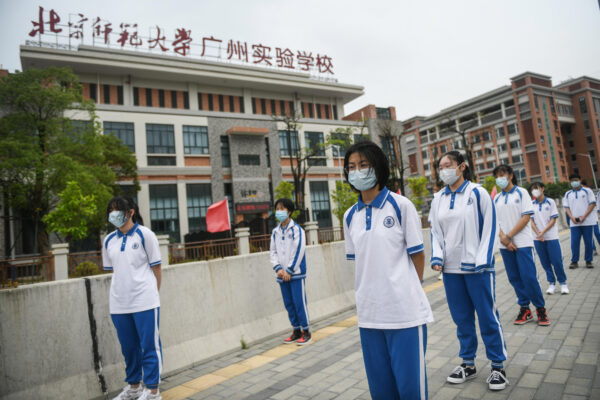 Os estudantes aguardam na fila para receber o teste de ácido nucleico para o vírus do PCC em uma escola de ensino médio em Guangzhou, China, em 21 de abril de 2020 (STR / AFP via Getty Images)