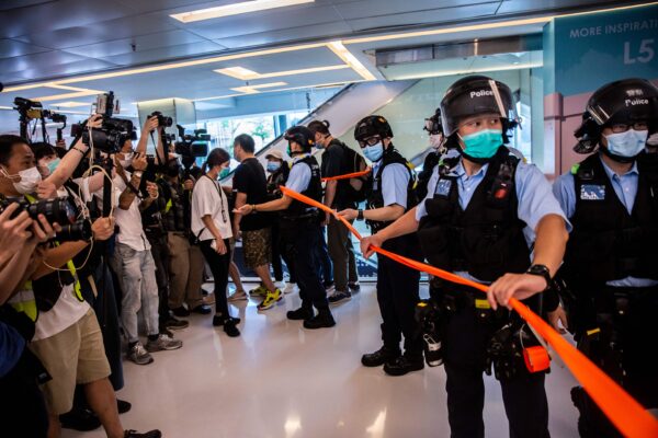 A polícia (direita) participa de uma operação de limpeza durante uma manifestação pró-democracia que pede a independência da cidade em um shopping em Hong Kong em 16 de maio de 2020 (Isaac Lawrence / AFP via Getty Images)