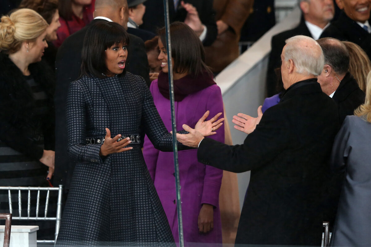 A primeira-dama Michelle Obama (à esquerda) cumprimenta o vice-presidente Joe Biden na plataforma de revisão como o desfile presidencial pela capital do país, em Washington, em 21 de janeiro de 2013 (Mark Wilson / Getty Images)