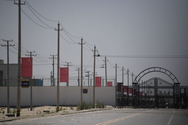 Esta foto tirada em 31 de maio de 2019 mostra bandeiras do regime chinês em uma estrada que leva a uma instalação que se acredita ser um campo de reeducação onde a maioria das minorias étnicas uigures e muçulmanas está detida nos arredores de Hotan, na região noroeste de Xinjiang, na China (GREG BAKER / AFP via Getty Images)