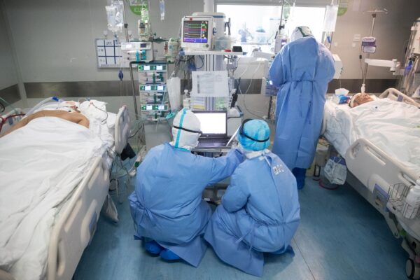 Uma equipe médica trata pacientes com vírus do PCC em um hospital em Wuhan, China, em 19 de março de 2020 (STR / AFP via Getty Images)