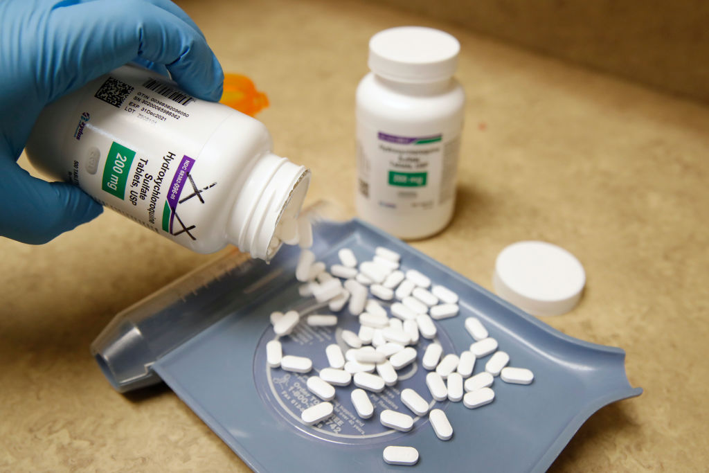 Um técnico de farmácia derrama pílulas de hidroxicloroquina na Rock Canyon Pharmacy em Provo, Utah, em 20 de maio de 2020 (George Frey / AFP via Getty Images)