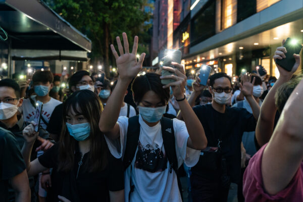 Jovens seguram as luzes do celular enquanto participam de um comício no distrito central de Hong Kong, em 9 de junho de 2020 (Anthony Kwan / Getty Images)