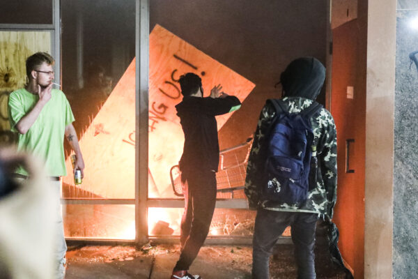 Os manifestantes atearam fogo em um banco do Wells Fargo do outro lado da rua da 5ª Delegacia de Polícia de Minneapolis durante a quarta noite de protestos e violência após a morte de George Floyd, em Minneapolis, Minnesota, em 29 de maio de 2020 (Charlotte Cuthbertson / The Epoch Times)