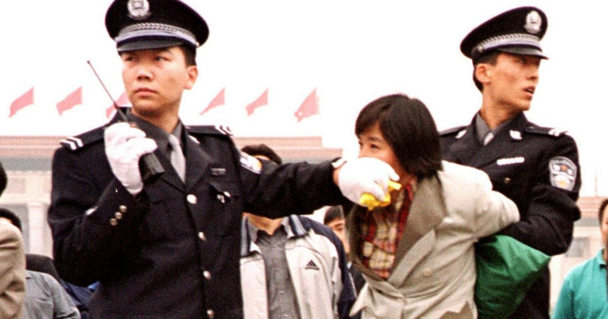Dois policiais chineses prendem um praticante do Falun Dafa na Praça Tiananmen, Pequim, em 10 de janeiro de 2000 (Minghui.org)